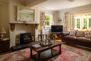 a living room with a couch and a fireplace at Pentre Bach in Llansantffraid Glan Conwy