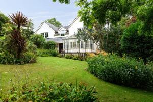 uma casa branca com um jardim e um quintal em Pentre Bach em Llansantffraid Glan Conwy