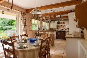 uma cozinha e sala de jantar com mesa e cadeiras em Pentre Bach em Llansantffraid Glan Conwy