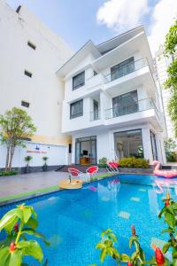 a villa with a swimming pool in front of a building at Minh Phước Villa 12 Kim Ngân in Vung Tau