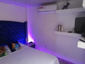 um quarto com uma cama branca e uma luz roxa em Apartamento# 7 - 2 habitaciones Cali sur em Cali