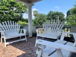 un grupo de sillas blancas sentadas en un patio en Casa 2 a 5 min del Irtra en Retalhuleu