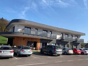 a parking lot with cars parked in front of a building at Apartmaji 5KA in Velika Loka