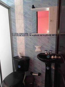 baño con aseo negro y lavamanos en Bosques de cuba, en Pereira