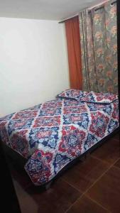 a bed with a quilt on it in a bedroom at Bosques de cuba in Pereira