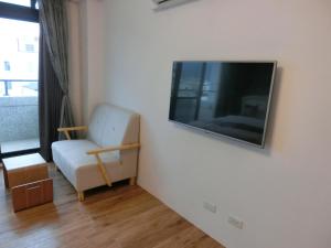 sala de estar con TV de pantalla plana en la pared en Chiyafonchin B&B, en Hualien City