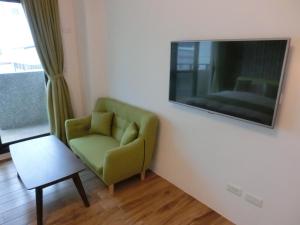 a living room with a green chair and a flat screen tv at Chiyafonchin B&B in Hualien City +15 photos