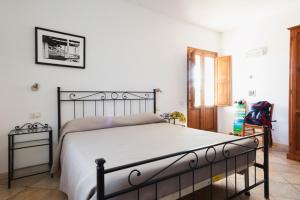 a bedroom with a large bed with white sheets at Agriturismo La Facenda in Albinia