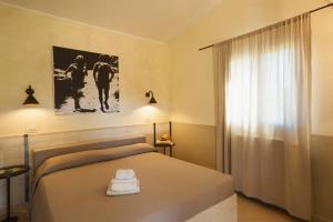 Un dormitorio con una cama grande y una ventana en Agriturismo La Facenda, en Albinia