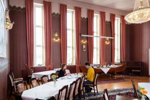 2 personnes assises à table dans un restaurant dans l'établissement Hotel Hospitz, à Savonlinna