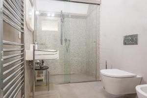 uma casa de banho com um chuveiro, um WC e um lavatório. em La Suite di Piazza dell'Università em Catânia