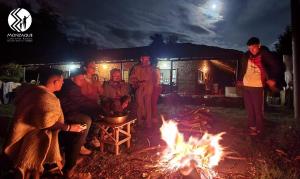 eine Gruppe von Menschen, die um ein Feuer stehen in der Unterkunft Monzaque- paraíso de bachué in El Barrial