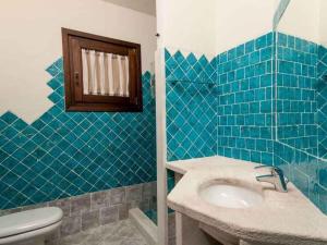 アッビアドリにあるHoliday home in Abbiadori 23079の青いタイル張りのバスルーム(洗面台、トイレ付)