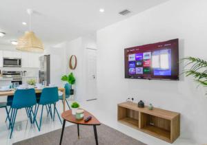 uma cozinha e sala de jantar com uma televisão na parede em Fantastic Brand New 3BD Duplex In Miami em Miami