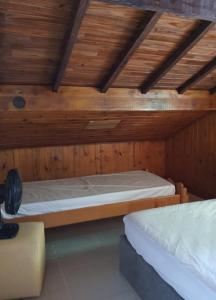 a bedroom with two beds in a wooden room at Encontro dos Mares Chalés Lázaro in Ubatuba
