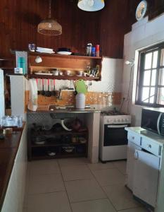 una cocina con estufa y hornilla horno superior en Encontro dos Mares Chalés Lázaro, en Ubatuba