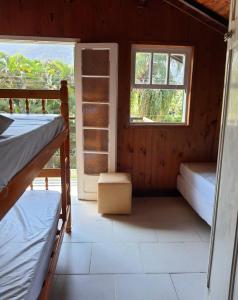 a room with two bunk beds and a window at Encontro dos Mares Chalés Lázaro in Ubatuba