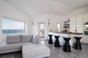 un soggiorno bianco con divano e cucina di Villa Azul by Klodge a Olbia