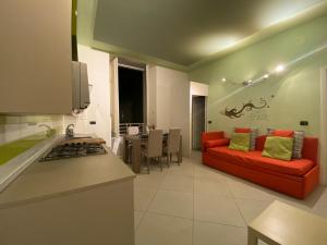 kuchnia i salon z czerwoną kanapą w obiekcie Partenope Comfort w mieście Napoli