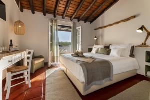 a bedroom with a bed and a desk and a window at Herdade do Sobroso Wine Hotel & Villas - Small Luxury Hotels of the World in Pedrógão +56 photos