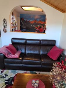 un divano in pelle nera in soggiorno con specchio di Apartment Kramer und Alpspitz a Garmisch-Partenkirchen