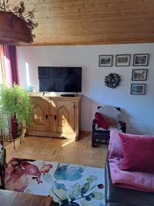 uma sala de estar com uma televisão de ecrã plano e um sofá em Apartment Kramer und Alpspitz em Garmisch-Partenkirchen