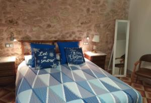 a bedroom with a bed with blue and white pillows at CAL COT in Hospitalet de l'Infant
