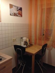 ニュルンベルクにあるシティ アパートメント イン ニュルンベルク アム プレラの小さなキッチン(木製のテーブルと椅子付)