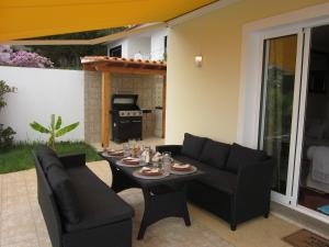 une terrasse avec une table, des chaises et une cuisinière dans l'établissement Villa Hansen in Garajau - Cristo Rei, à Caniço