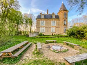 een oud gebouw met een picknicktafel ervoor bij Private Castle with Park - Château Guillermo in La Moncelle
