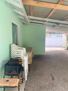 a room with two white chairs and a table at Casa da Vila in Porto Belo