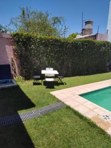 a backyard with a table and a swimming pool at EDU's HOUSE I in Guaymallen