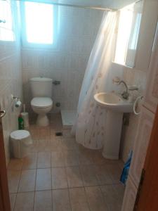 y baño con aseo y lavamanos. en Irini's Appartment 2, en Néa Koútali