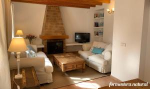 a living room with a couch and a fireplace at Casa Reme Sant Francesc - Formentera Natural in Sant Francesc Xavier