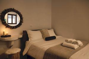 1 dormitorio con cama con espejo y lavamanos en Plaza Guest House με Tζάκι, en Arachova