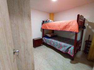 Dormitorio con litera y sábana naranja en Hermoso y nuevo apartamento en Santa Rosa de Cabal, en Santa Rosa de Cabal