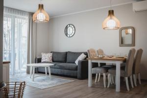 uma sala de estar com um sofá e uma mesa em Apartament Rezydencja Park 3 em Mielno