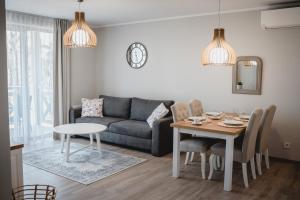 uma sala de estar com um sofá e uma mesa em Apartament Rezydencja Park 3 em Mielno