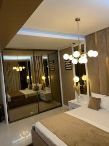 SAS 2 Luxury Apartments في مامايا: غرفة نوم بسرير ومرآة كبيرة