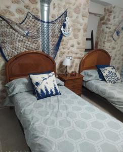 a bedroom with two beds with blue and white pillows at CAL COT in Hospitalet de l'Infant