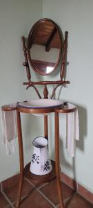 una silla de madera con un espejo encima en Casa Rural Roja, en Cebreros