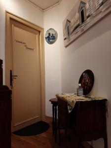a room with a door and a table and a clock at CHARLES AU PREMIER in Le Mêle-sur-Sarthe