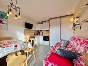 salon z czerwoną kanapą i stołem w obiekcie Appartement rénové avec terrasse, proche ski-bus et commerces, Notre-Dame-de-Bellecombe - FR-1-505-178 w mieście Notre-Dame-de-Bellecombe +13 zdjęć