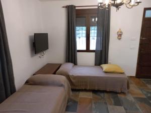 Habitación con 2 camas, TV y ventana. en Senia Tomaset III, en Onil