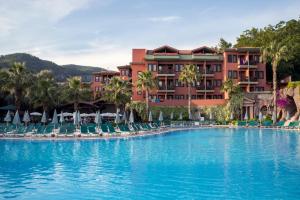a resort with a large swimming pool with chairs at Sundia By Liberty Suncity in Oludeniz