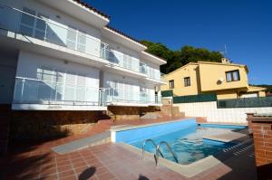 a house with a swimming pool in front of a building at Apartamentos Bonsol in L'Estartit
