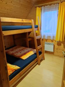 Dolní Moravice的住宿－Chaty ve Ski-relax Avalanche Dolní Moravice，小屋内设有一间带两张双层床的卧室