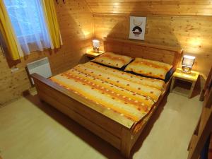 a bedroom with a bed with two lamps on tables at Chaty ve Ski-relax Avalanche Dolní Moravice in Dolní Moravice