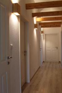 un corridoio vuoto con soffitti in legno e una porta bianca di Ferienwohnung Stefanko a Bernau