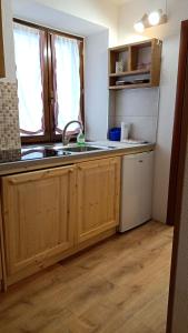 a kitchen with wooden cabinets and a sink and a window at CasaMau Bilo in Pera